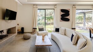 Un soggiorno moderno con camino, un divano, un tavolino e una TV a parete.