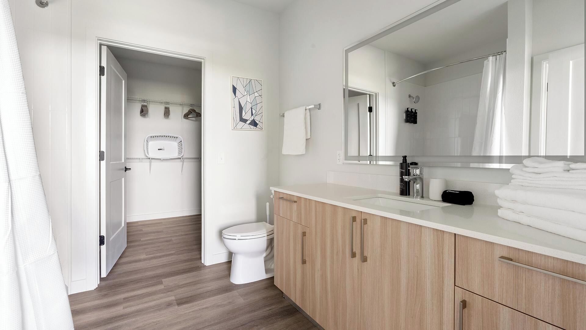 Une salle de bain moderne avec des toilettes, un lavabo et un miroir.