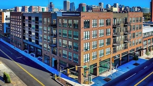 A multi-story building with a sign for 'LIVECOMMODORE.COM' indicating a commercial space. - Landing | Incredible 2BD, Pool, Courtyard (Richmond)