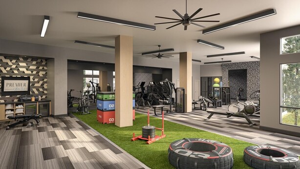 Ein modernes Fitnessstudio mit unterschiedlichen Trainingsgeräten, einem an der Wand befestigten Schild und einem Fenster mit Blick auf Bäume.