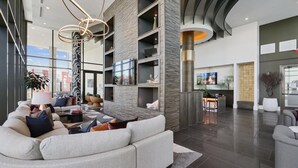 En rummelig lobby med et moderne design, med et stort siddeområde, en bar og et tv.