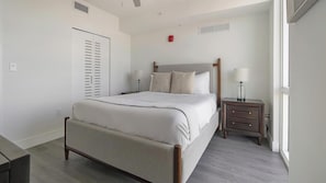 A bedroom with a bed, bedside tables, a wardrobe, and a window.