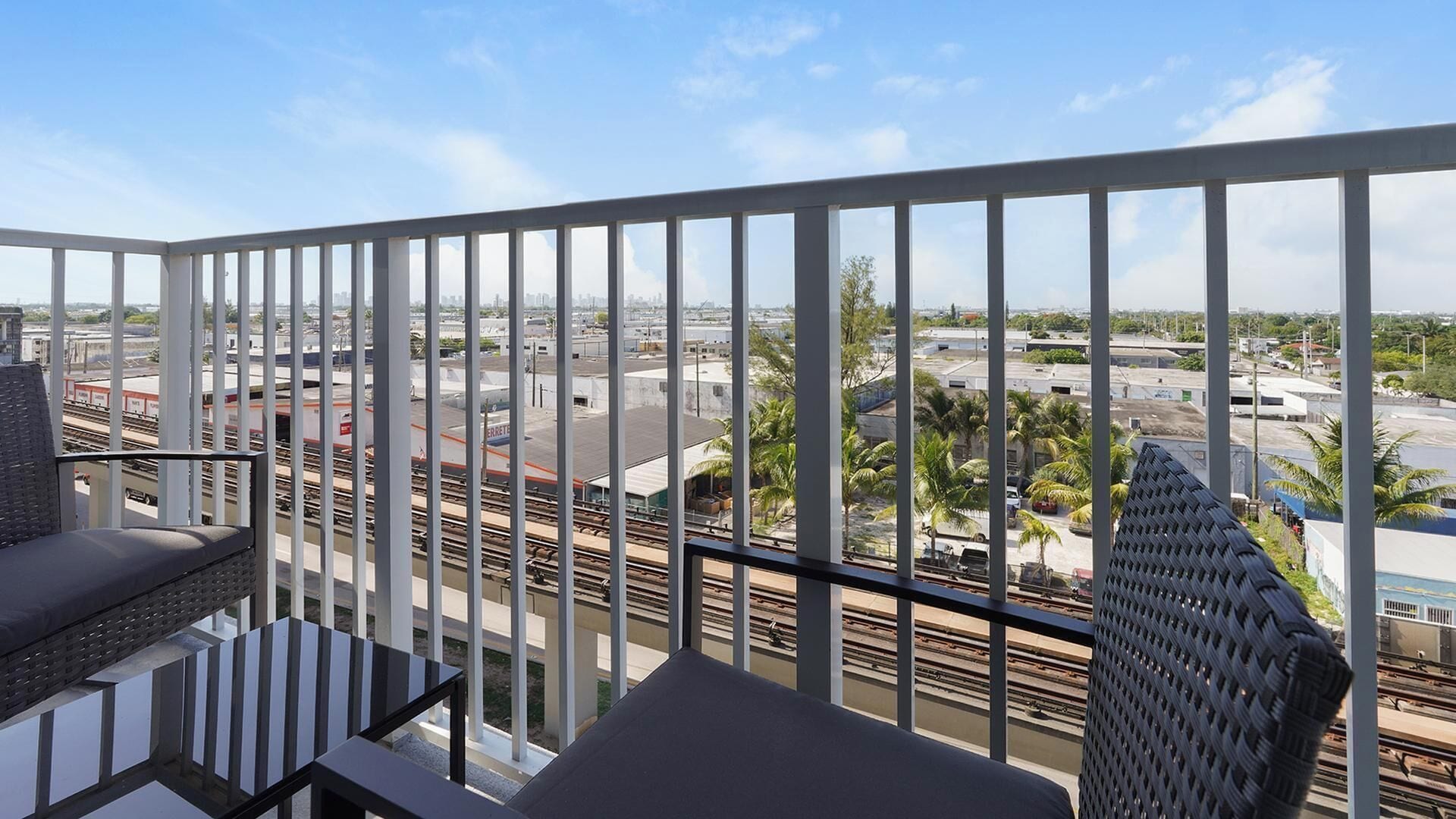 Un balcon donnant sur une gare et les bâtiments environnants.