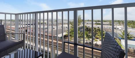 Un balcon donnant sur une gare et les bâtiments environnants.
