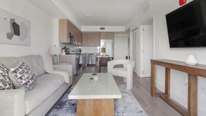Ein modernes Wohnzimmer mit einer Couch, einem Couchtisch und einem Fernseher.