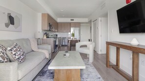 Ein modernes Wohnzimmer mit einer Couch, einem Couchtisch und einem Fernseher.