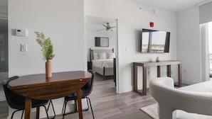 A modern bedroom with a bed, bedside table, and a ceiling fan. - Landing | Spectacular 1BD, Gym (Hialeah)