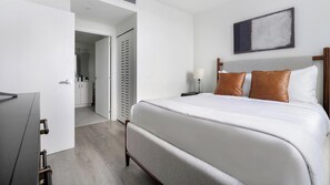 Ein Hotelzimmer mit Bett, Fernseher, Kleiderschrank und einem Bild an der Wand.