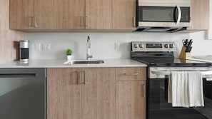 A modern kitchen with wooden cabinets, a stainless steel sink, an LG microwave, and an oven.
