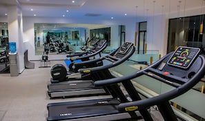A gym with treadmills, weight machines, and a mirrored wall. - Red Apple Haven (Accra)