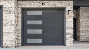 Eine Garagentür mit Steinverkleidung und der Nummer 15 darüber.