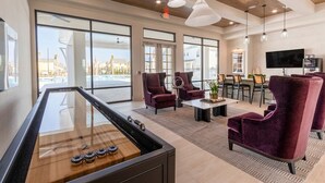 A spacious living area with a pool view, a pool table, and modern furniture.