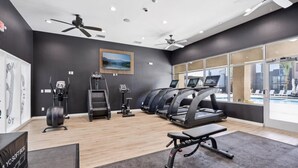 Ein Fitnessstudio mit Laufbändern, Ergometer und einer Bank.