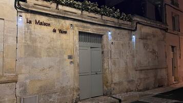 Un bâtiment en pierre avec une enseigne indiquant « La Maison de Yann » et une porte à deux battants.