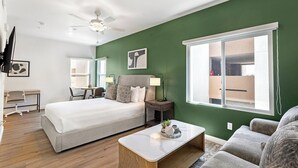 Een hotelkamer met een bed, nachtkastje, lamp en uitzicht.