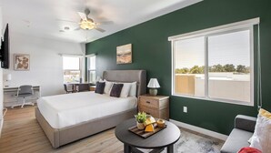 A hotel room with a bed, desk, chair, and a large window. - Landing | Amazing Studio, Clubhouse, Gym (North Las Vegas)