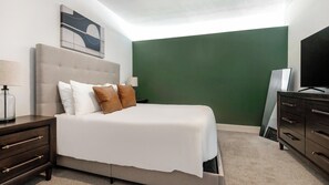 A bedroom with a bed, nightstands, a dresser, and a television. - Landing | Incredible 1BD, Gym, Yoga Studio (St. Louis)