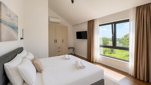 Una camera da letto con un letto, una televisione, un armadio e una finestra vista.