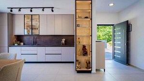 Una cucina moderna con mobili a incasso, un'isola centrale e una cantinetta per il vino.