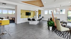 A modern hotel interior with a kitchen area, dining space, and seating area. - Landing | Spectacular 2BD in St. Cloud (Kissimmee)