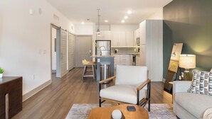 A modern living room with a sofa, armchair, and coffee table. - Landing | Chic 1BD in St. Cloud (Kissimmee)