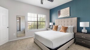 A bedroom with a large bed, bedside lamps, a window with blinds, and a wall-mounted artwork. - Landing | Amazing 3BD, Gym (Lewisville)