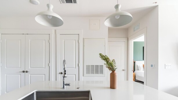 A modern kitchen with a central island, white cabinetry, and pendant lighting. - Landing | Amazing 1BD, Gym, Rooftop Lounge (Frisco)