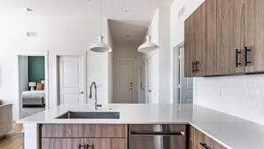 Eine moderne Küche mit Kochinsel, Edelstahlgeräten und Holzschränken.