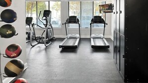 A gym with treadmills, an elliptical, and various exercise balls. - Landing | Beautiful 2BD, Gym, Pool (Nashville)