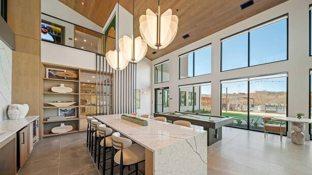 A modern kitchen with a marble island, bar stools, and a pool table. - Landing | Beautiful 2BD, Courtyard, Gym (Dallas)