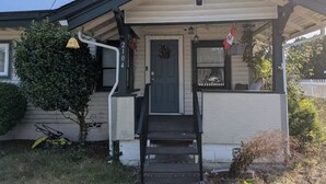 A residential house with a front porch, a door, and a small garden area.