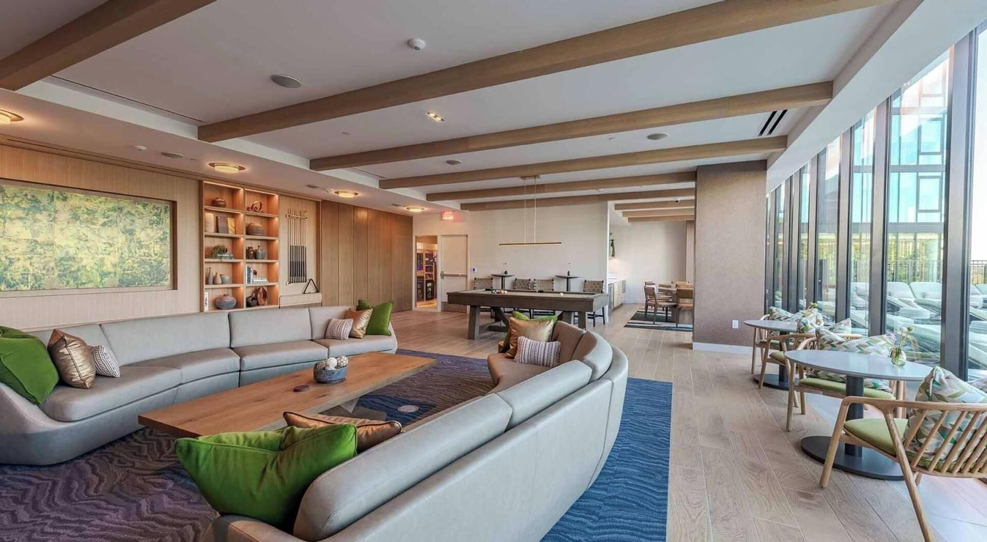 A spacious living area with a large sofa, a coffee table, and a pool table.