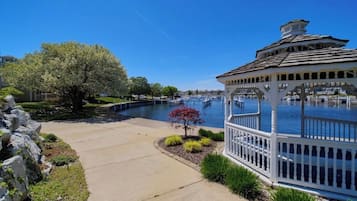 A gazebo by a lake with a clear sky.