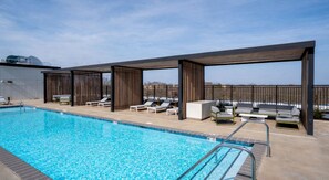 A swimming pool with lounge chairs and a covered seating area. - Landing | Modern Studio in Caraleigh (Raleigh)