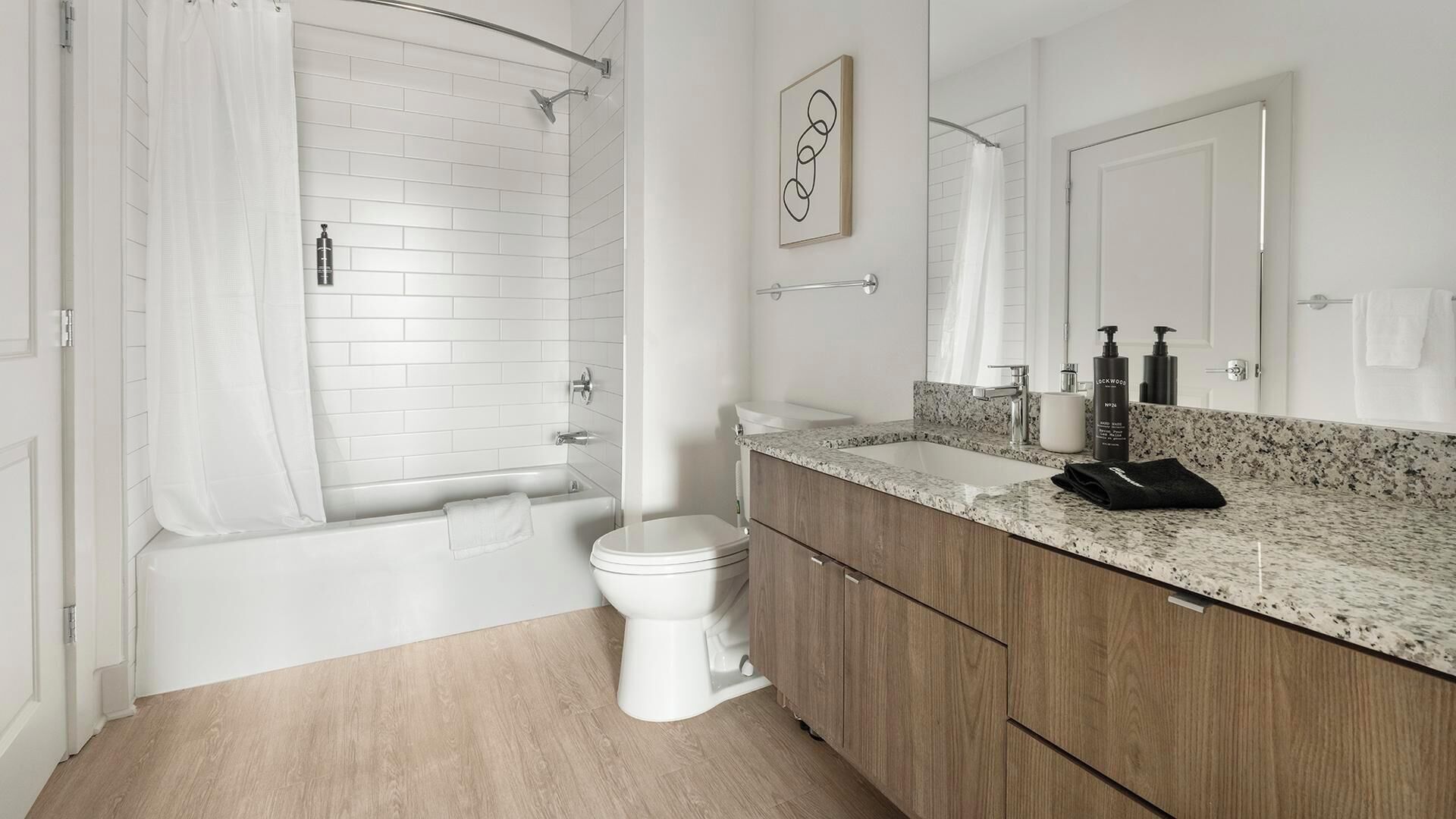 Une salle de bain moderne équipée d’une douche, de toilettes et d’un meuble-lavabo.