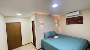 Una camera da letto con un letto, una porta, un condizionatore d'aria e luci a parete.
