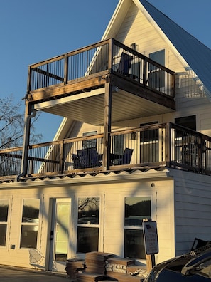 A two-story building with a wooden balcony, a sign indicating veteran parking, and a clear sky.