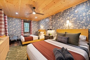 Ein gemütliches Schlafzimmer mit zwei Betten, einer Holzbalkendecke und einem blumigen Wanddesign.