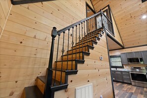 Ein Holzinnenraum mit Treppe, Küchenbereich und Einbauzimmereinrichtung.