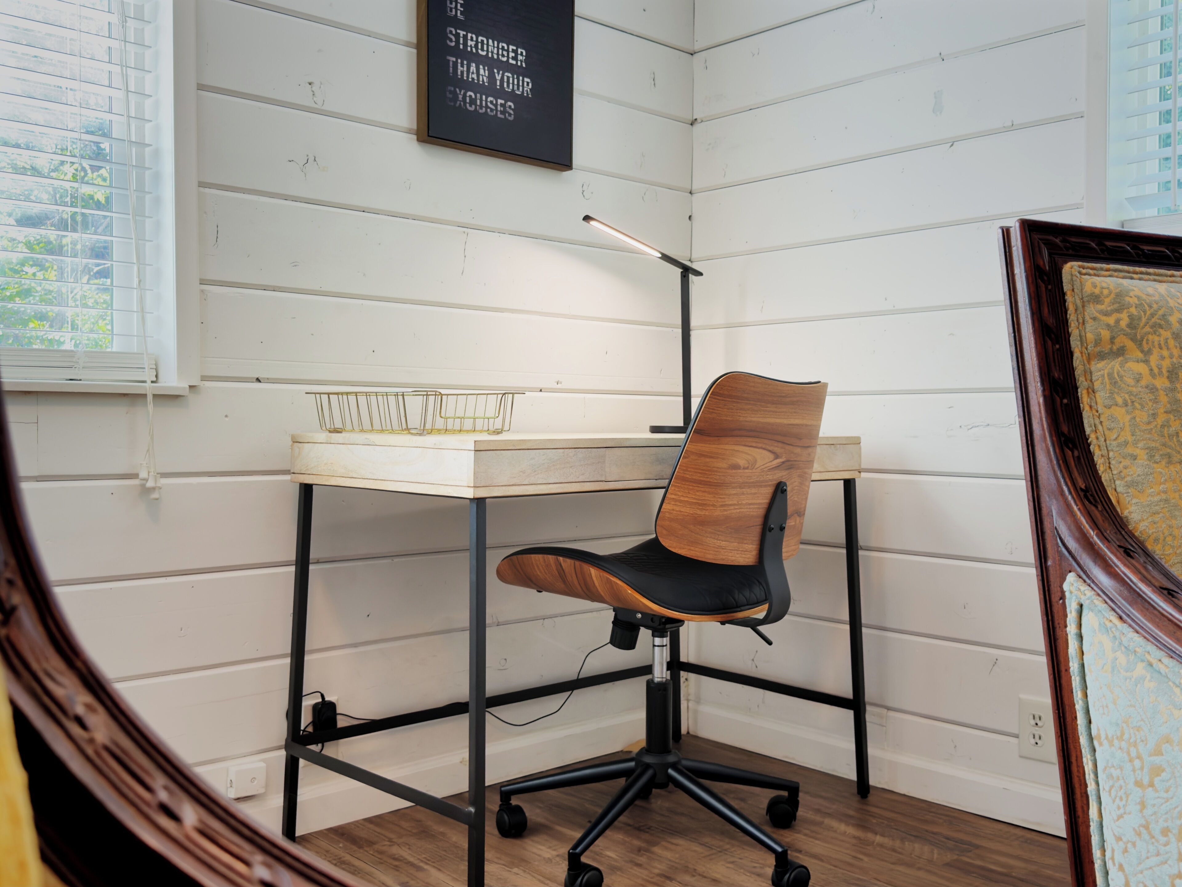 A workspace with a desk, chair, and a motivational poster on the wall.