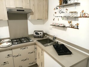 Una cocina con extractor Bosch, tostadora, fregadero y armarios con la marca LUXA.