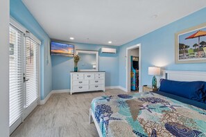 A bedroom with a bed, dresser, and a painting on the wall.