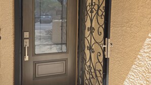 A closed door with a glass panel and a decorative metal gate. - Beautifully decorated single-level private townhome in the heart of Oro Valley. (Tucson)