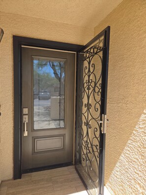 A closed door with a glass panel and a decorative metal gate. - Beautifully decorated single-level private townhome in the heart of Oro Valley. (Tucson)