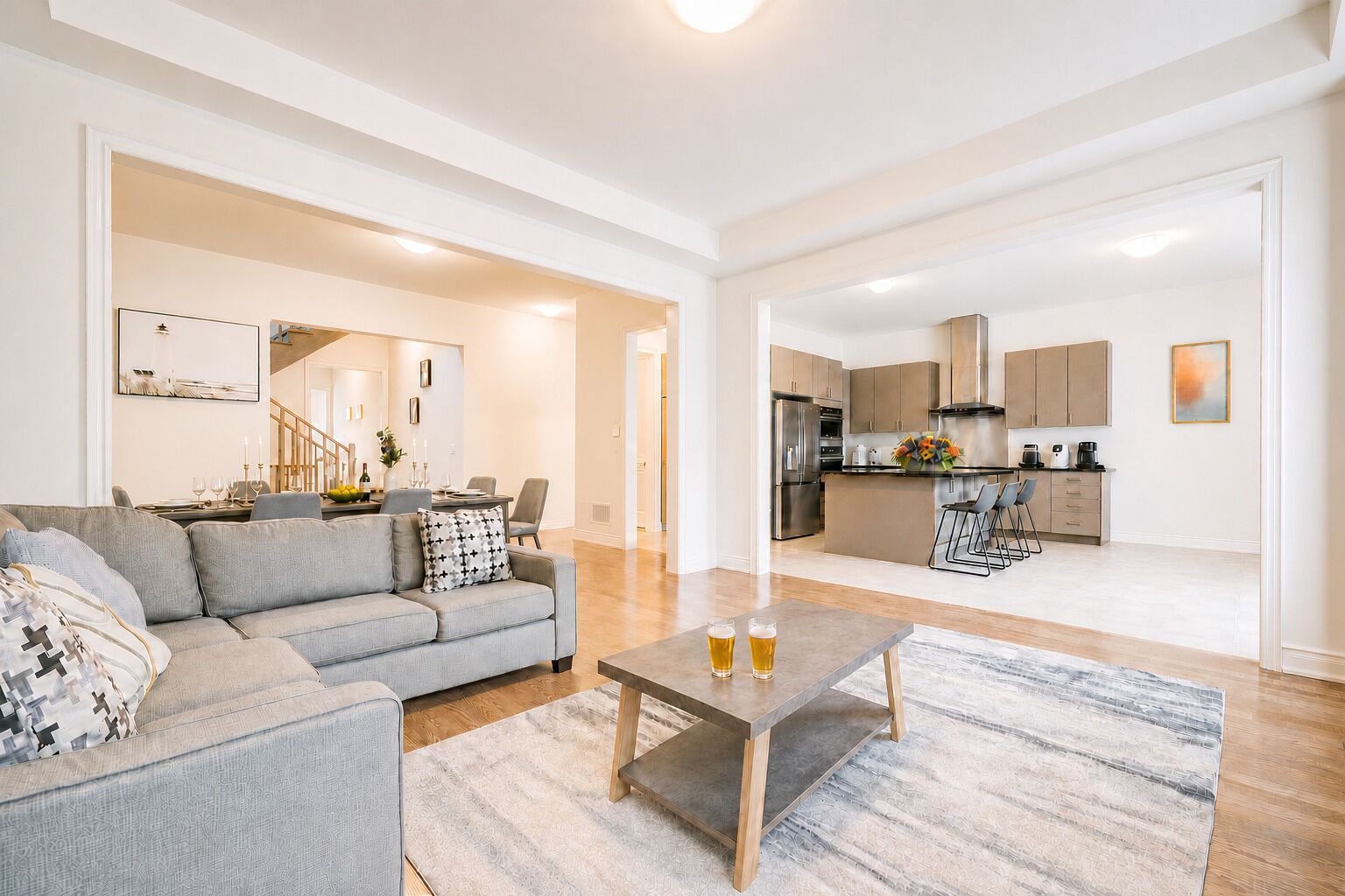 Un salon moderne comprenant un canapé, une table basse et un coin repas avec des chaises.