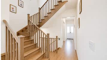 Bright entryway with warm wood floors and a beautiful open staircase