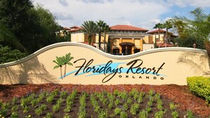 Schild für das Floridys Resort in Orlando mit geschwungener Oberseite und Palmen.