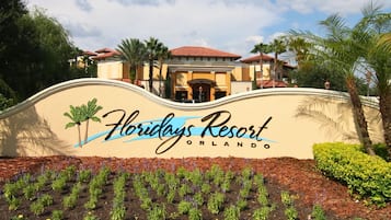 A sign for Floridys Resort in Orlando with a wavy top and palm trees.
