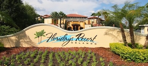 A sign for Floridys Resort in Orlando with a wavy top and palm trees. - 3BR Floridays Suite on I-drive (Orlando)