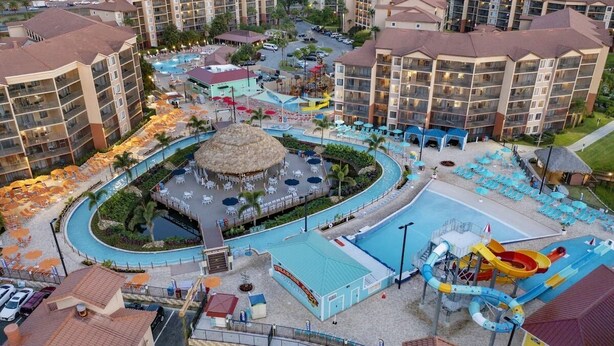 A resort with multiple swimming pools, a water park, and a central circular area with a thatched roof. - Apartment in Orlando, near the theme parks. (Orlando)